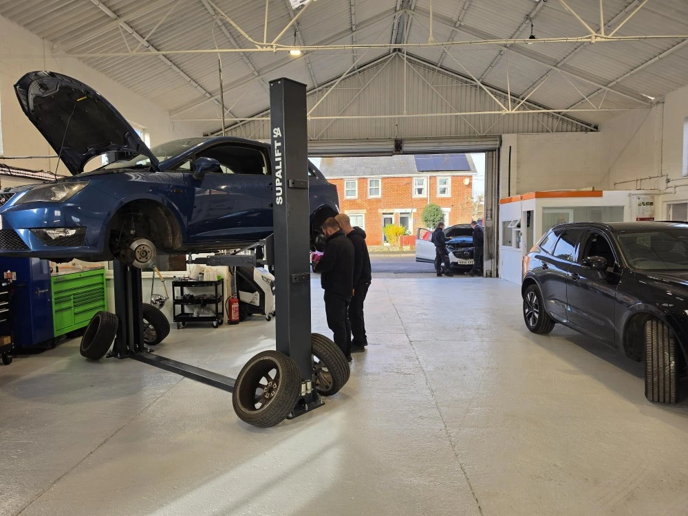 Best Garages technicians working on a vehicle on the two-post lift
